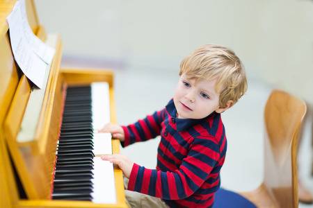 35233005-two-years-old-happy-toddler-boy-playing-piano-early-music-education-for-little-kids-child-at-school