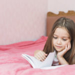 girl-lying-bed-reading-book